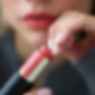 A close-up of a peach lipstick tube with a vibrant color swatch on a hand.